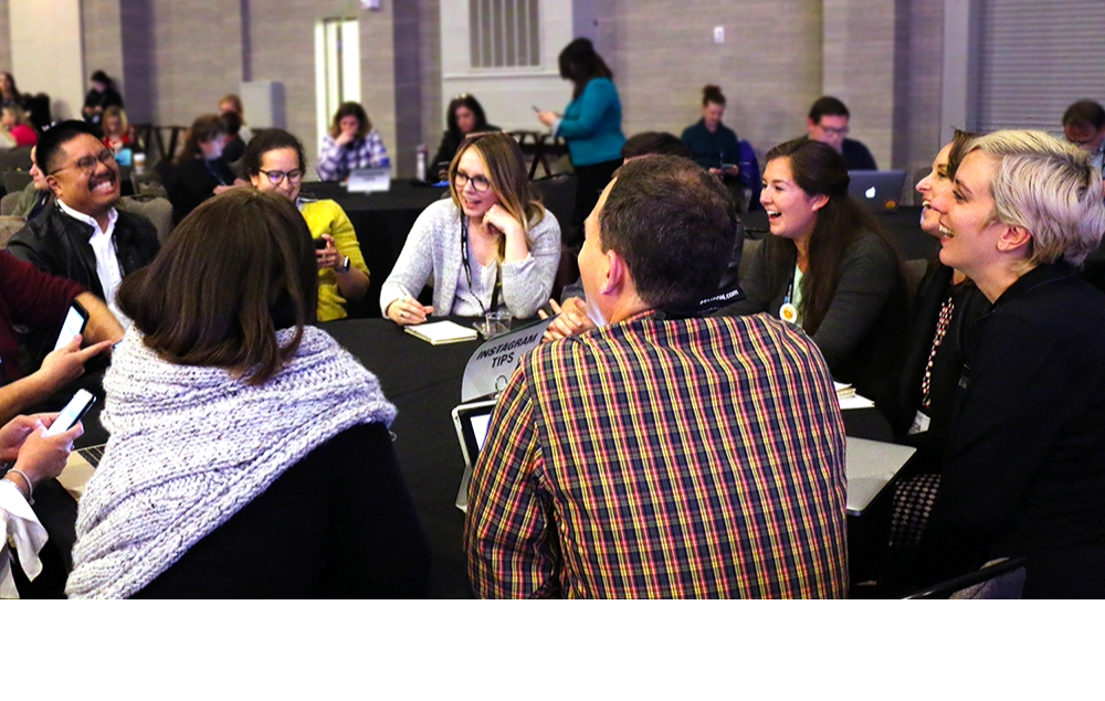 Attendees collaborating and laughing with each other at a roundtable
