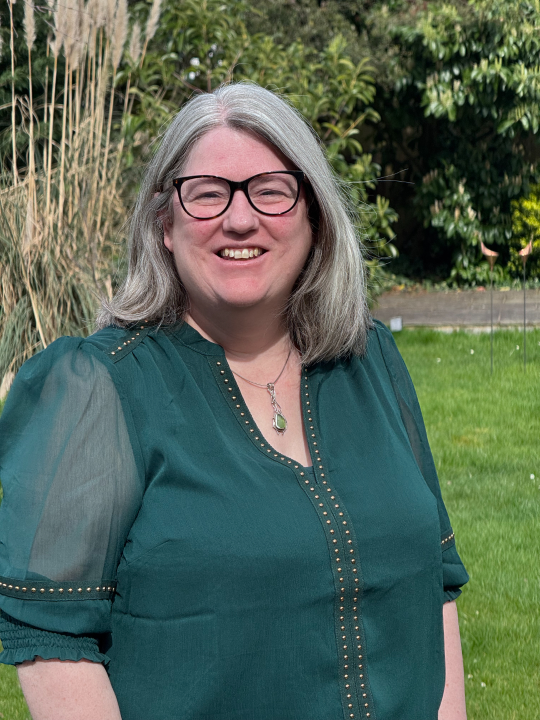 Lynsay OT supervisor looking straight at the camera with glasses on and white and blue blouse