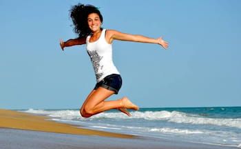 jumping happy woman at the beach 