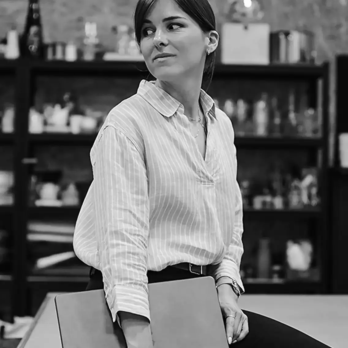 Janice, noir et blanc, qui regarde en arriĂšre, son ordinateur Ă la main