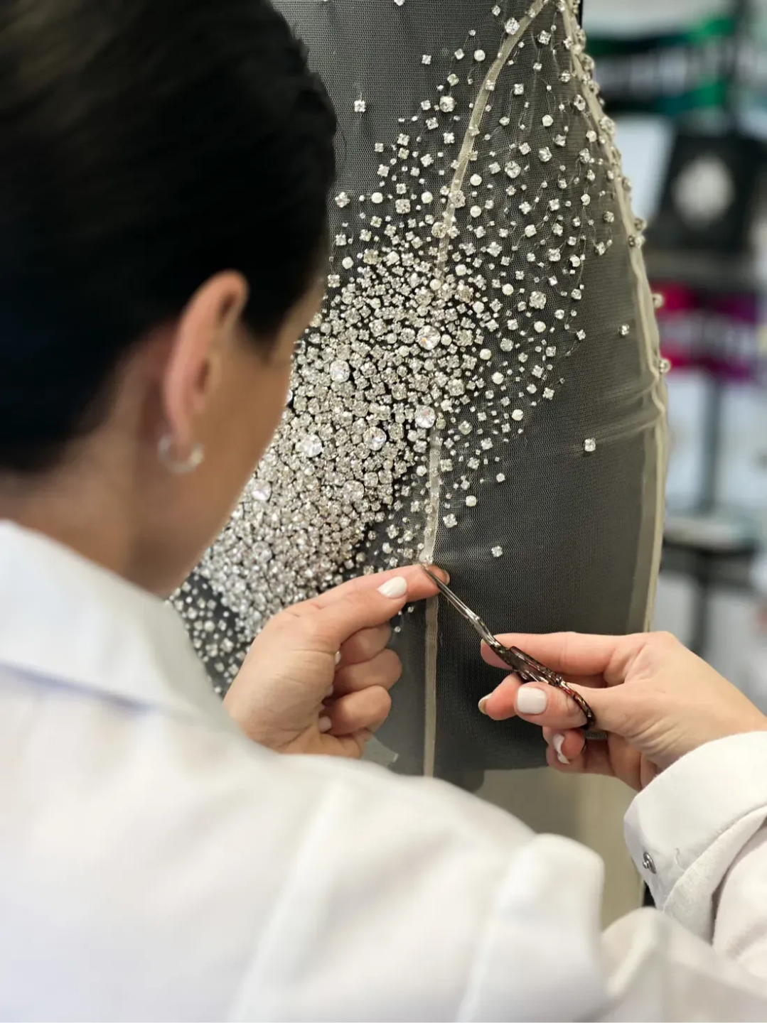Valeria Fic embroidering crystals on a couture dress in her atelier
