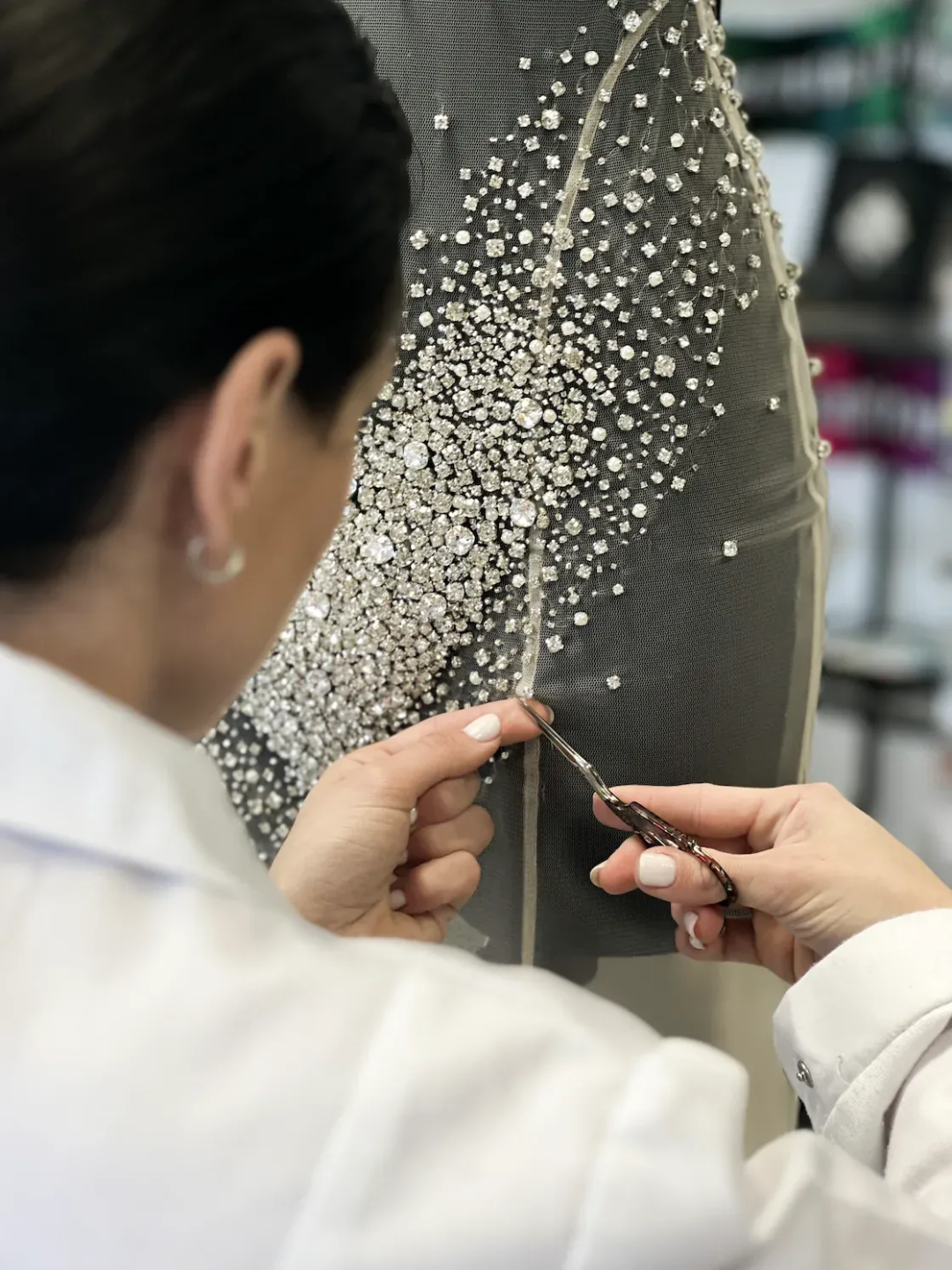 Close-up of hand beadwork on a sheer couture embroidery panel