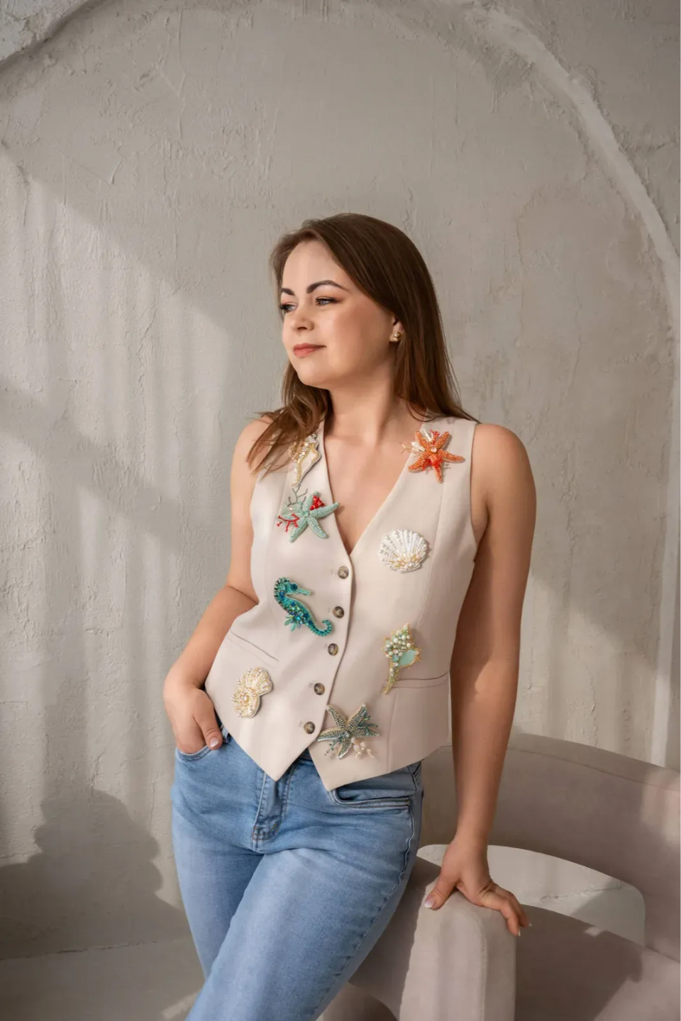 Eveline, founder of EWE MAGIC, wearing her hand-embroidered vest with brooch details