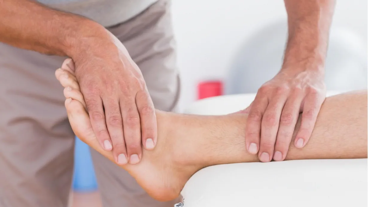 Clinician performing fascial manipulation on a patient's ankle