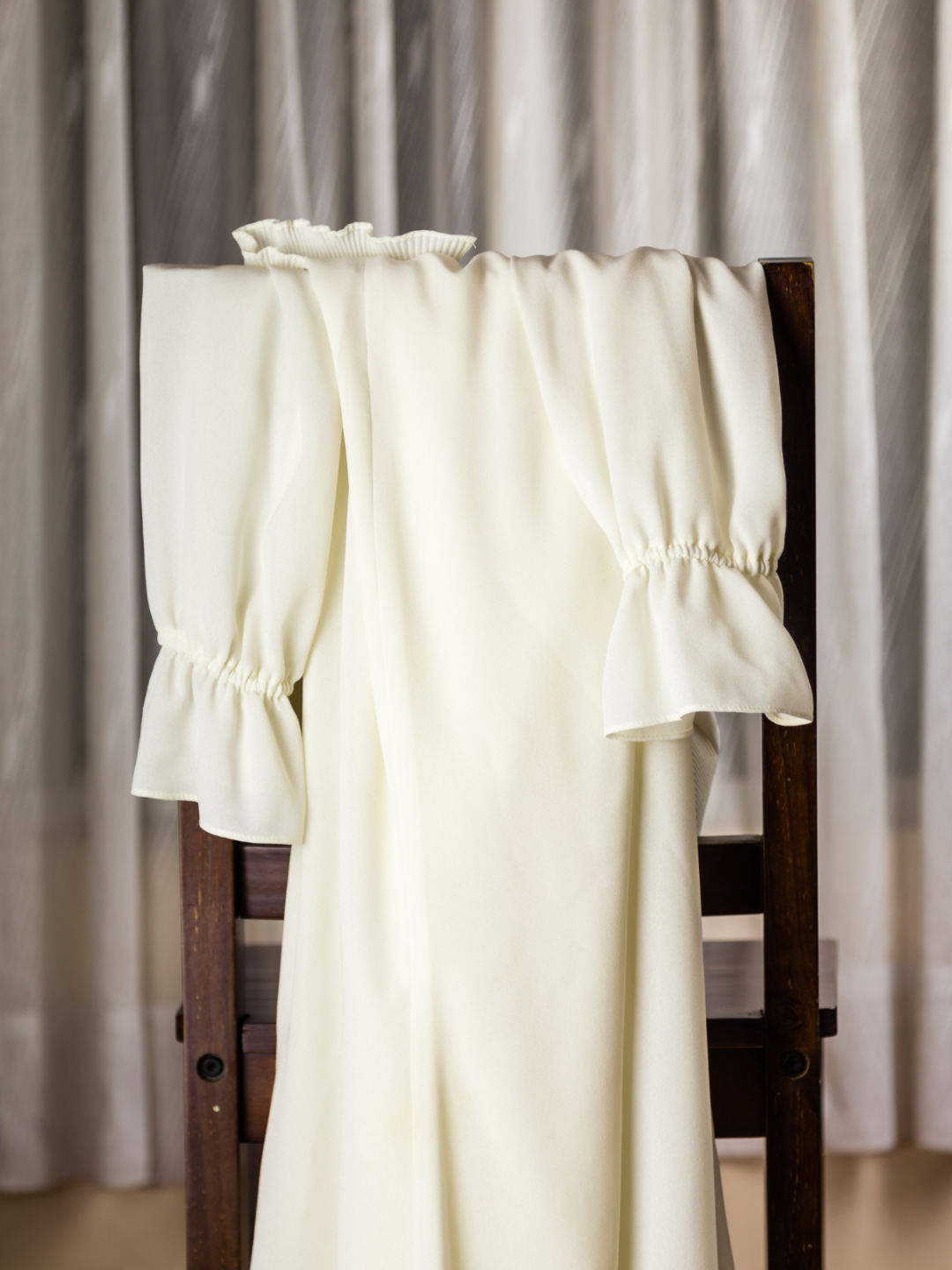 soft cream robe laid across a chair- serene wellness moment