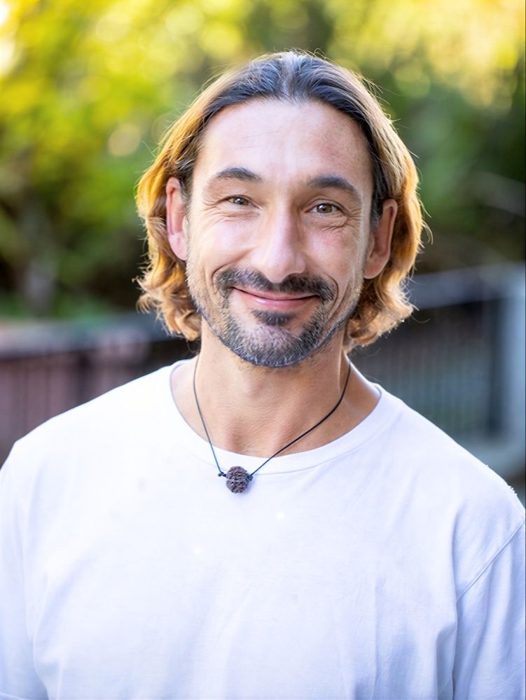 Close-up portrait of Dr. Nibodhi smiling warmly on the About page