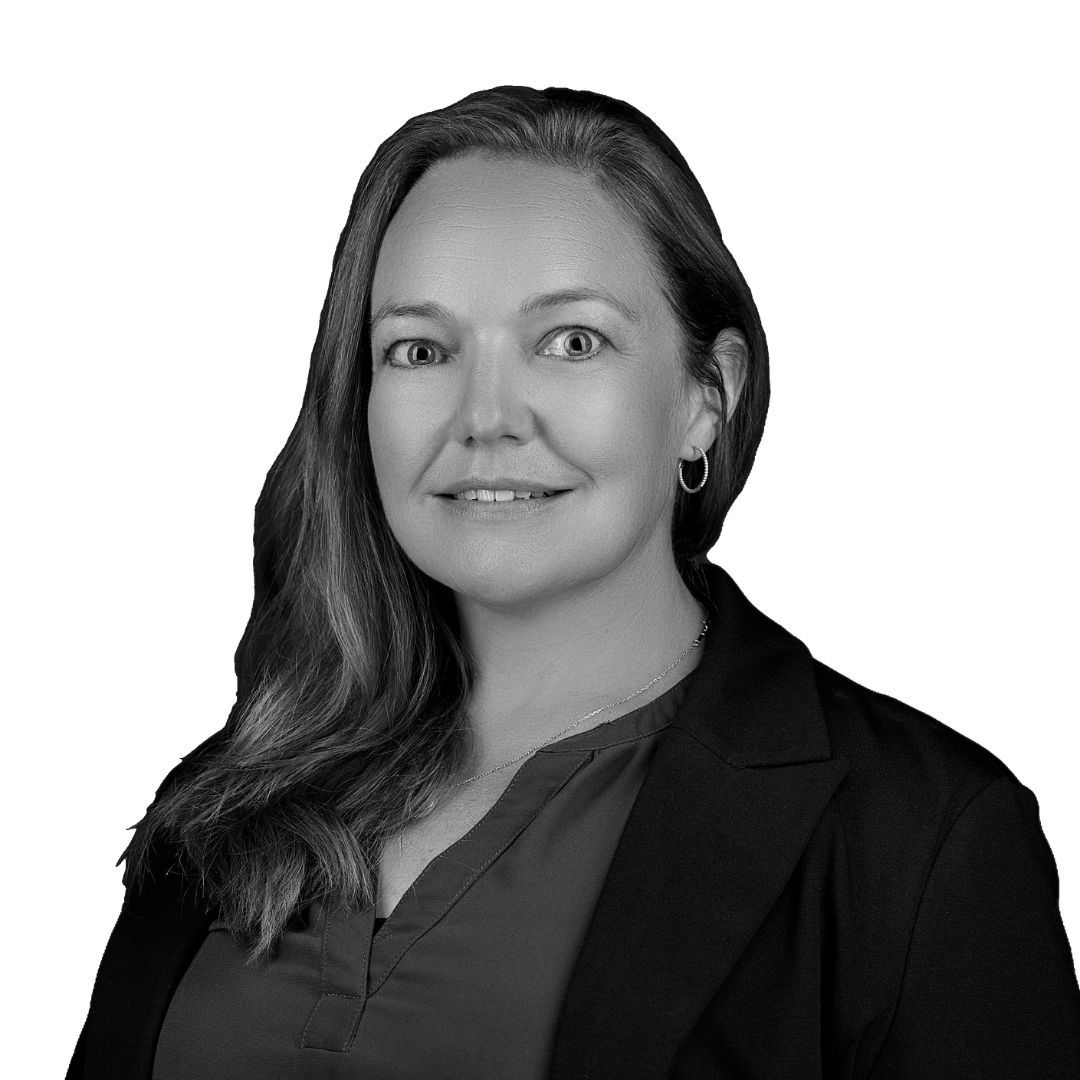 Woman with long straight hair wearing a blazer and blouse with hoop earrings, facing forward against a plain background
