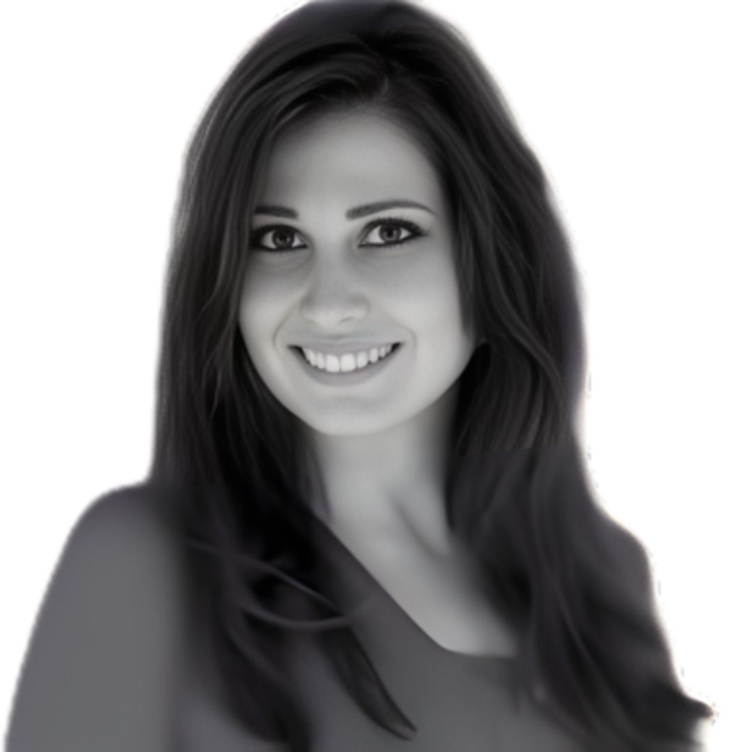 Smiling woman with long straight hair wearing a dark top, facing forward against a plain background