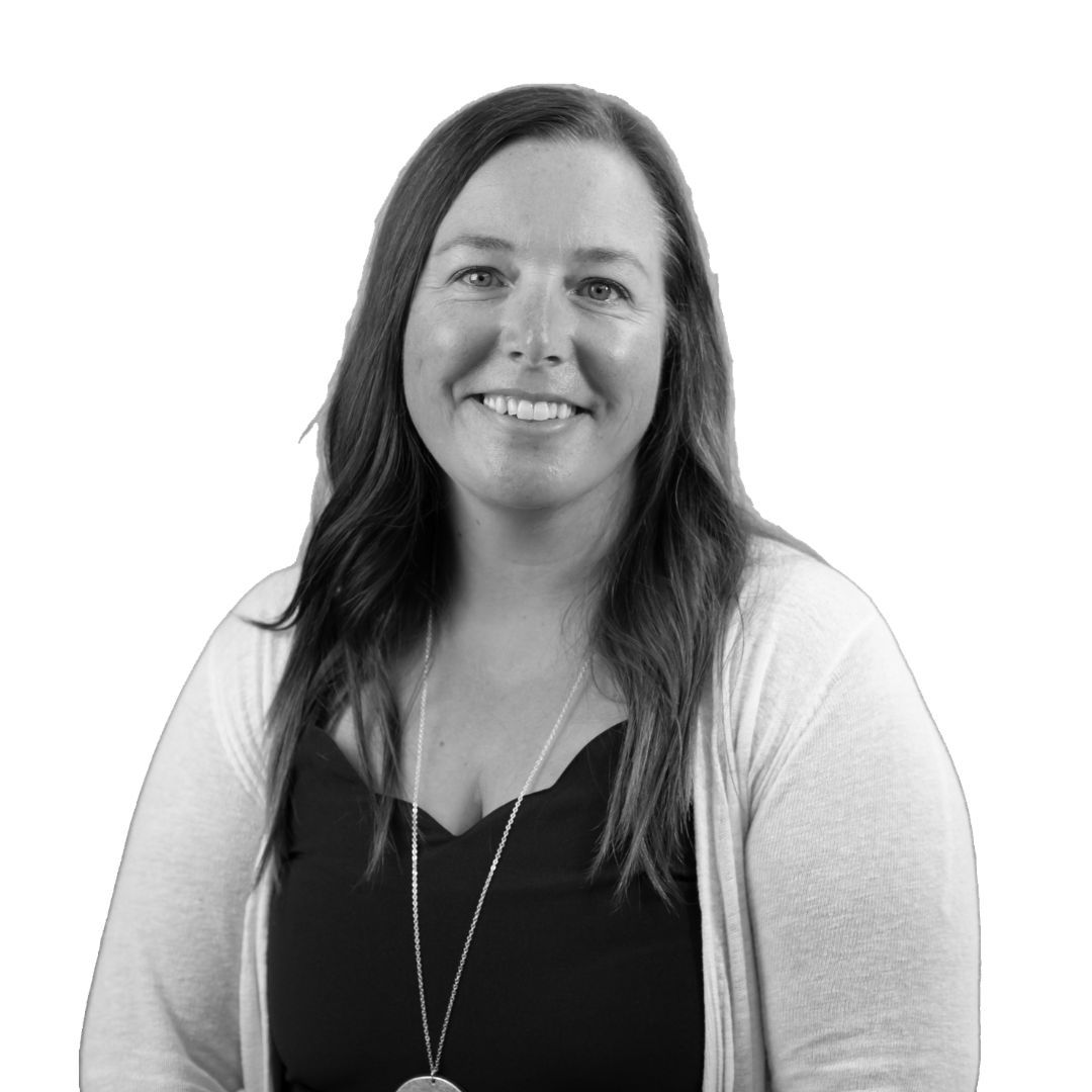 Smiling woman with long straight hair wearing a dark top and light cardigan with a necklace, facing forward against a plain background