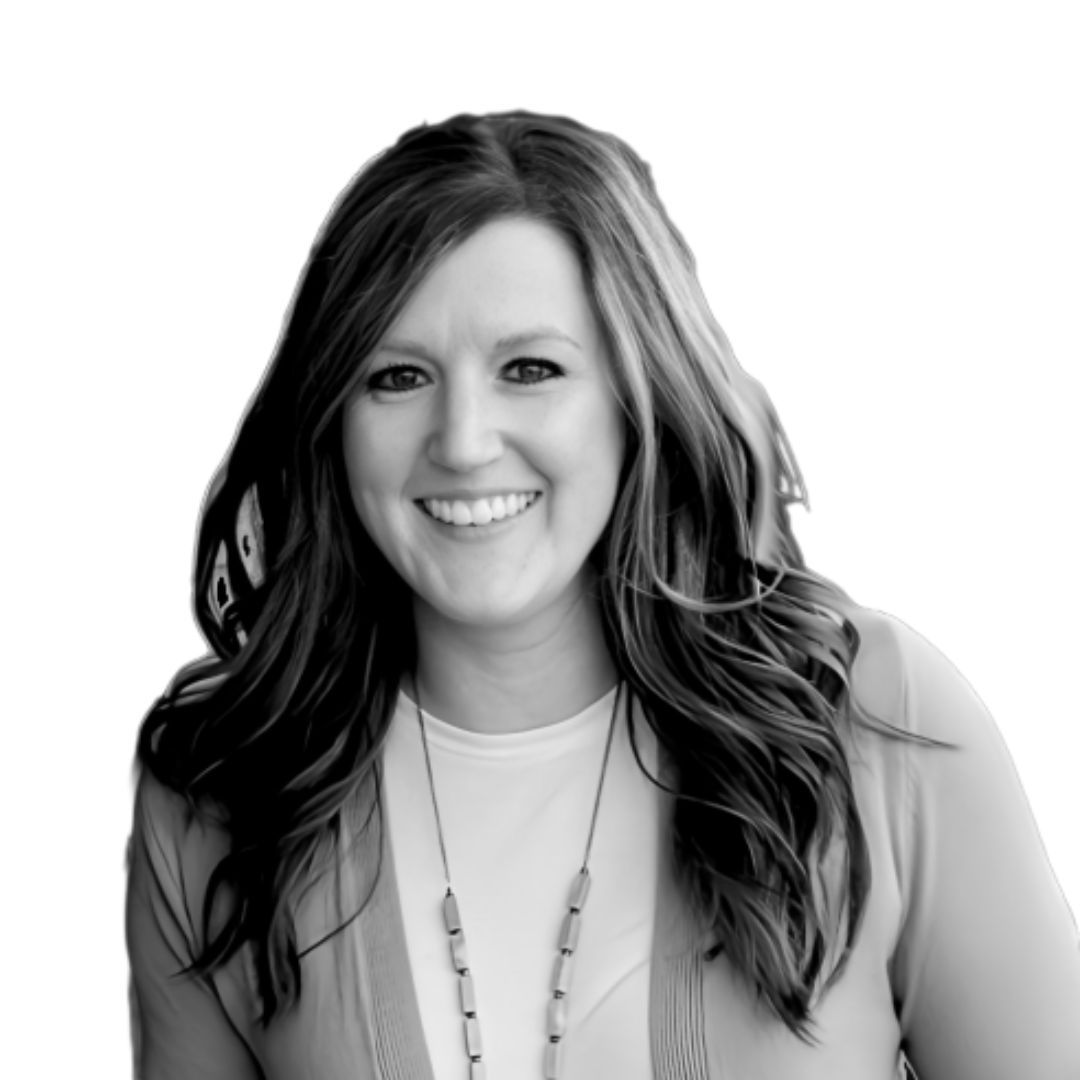 Smiling woman with long wavy hair wearing a light top and necklace, facing forward against a plain background