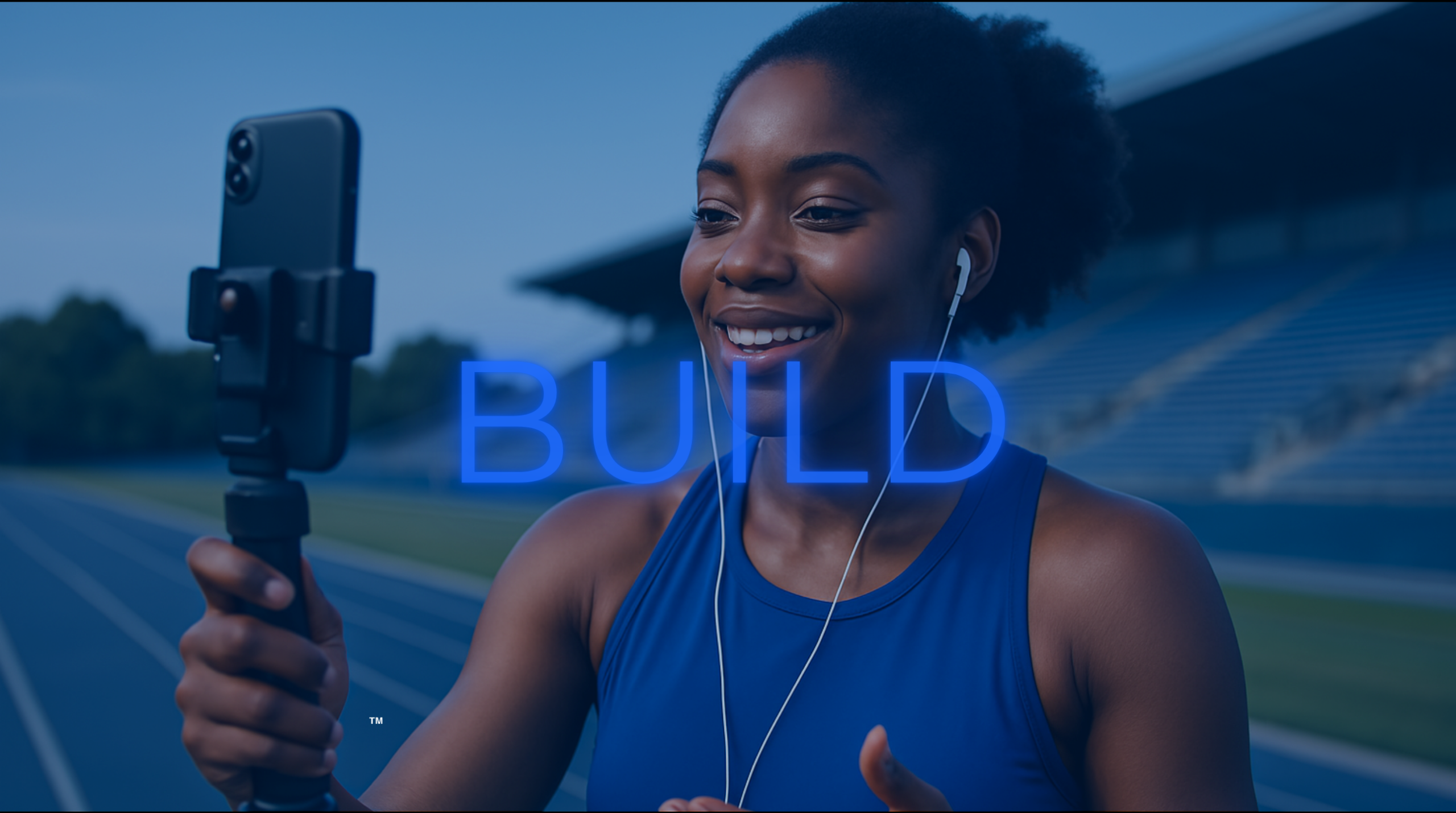 Young Black female athlete filming content with a phone, smiling and focused — representing content creation and audience growth.