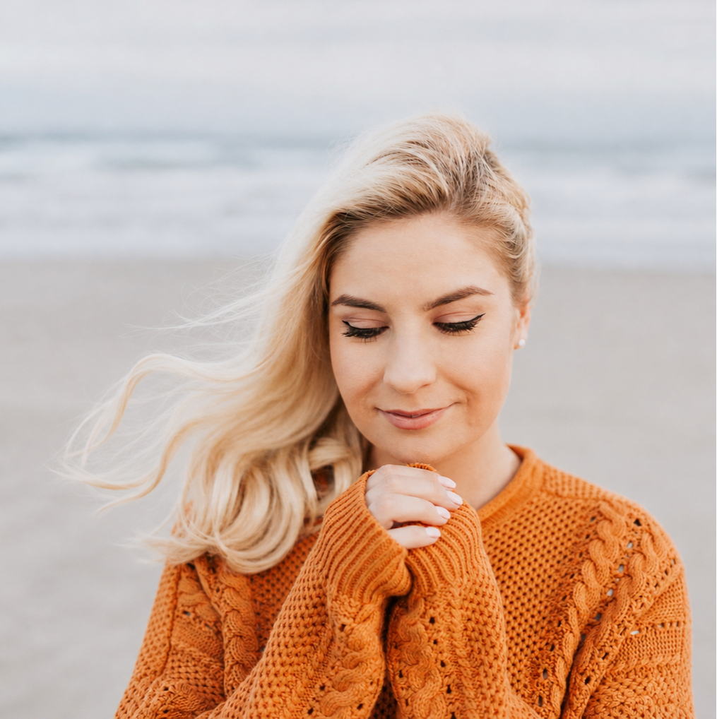 Woman with her hand over her heart reflecting during a heart-centered coaching exercise.