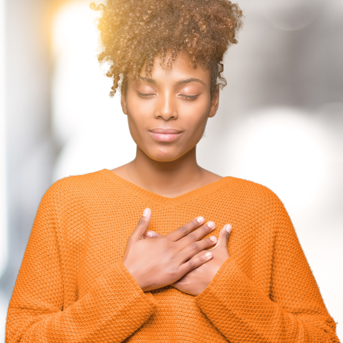 Woman with her hand over her heart reflecting during a heart-centered coaching exercise.