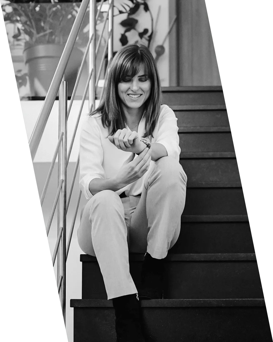 Image de Janice Kerschbaumer qui regarde sa montre en étant assise sur un escalier