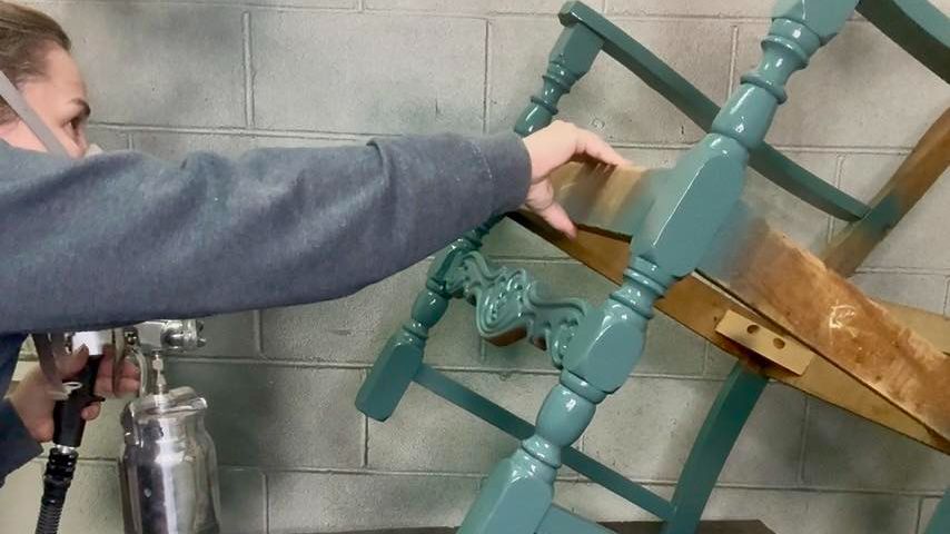 Sierra demonstrating how to paint a chair frame
