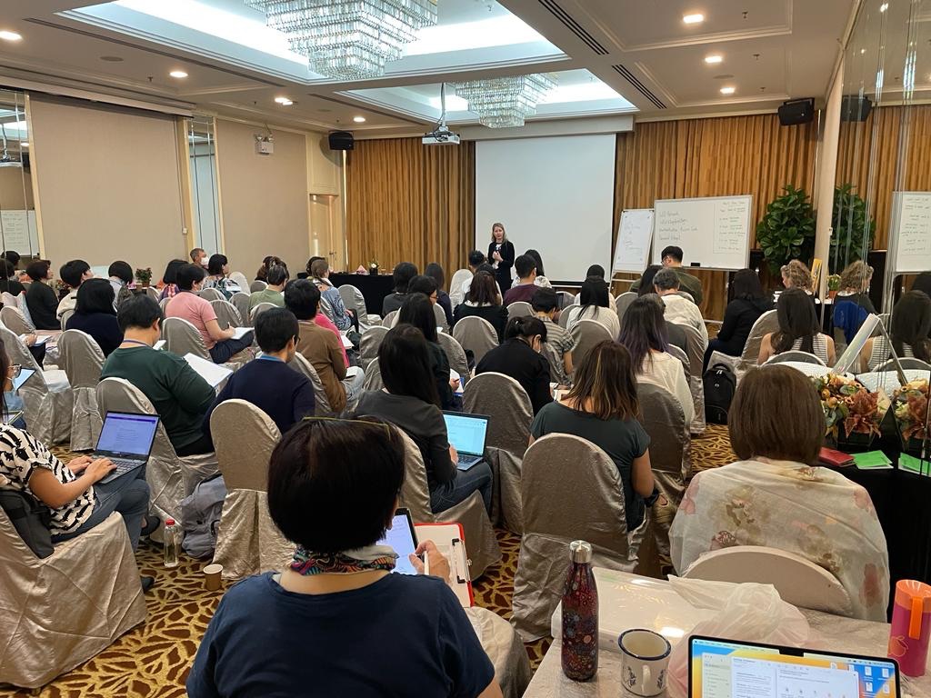 Dr. Abi Blakeslee presenting in front of a live group of professionals