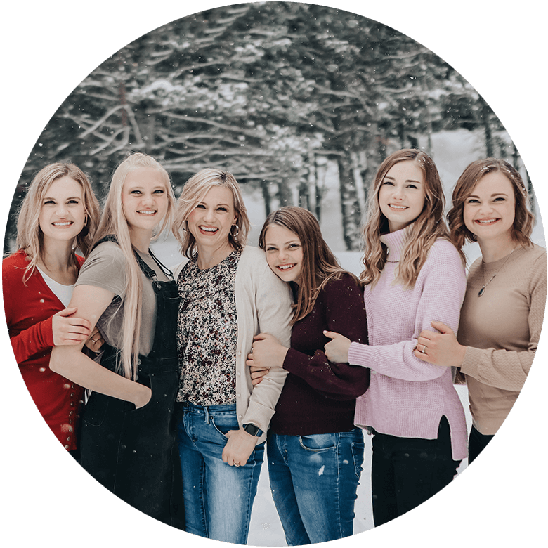 Steh Chaffee and daughters smiling and embracing while posing for a group photo with a snowy winter background, symbolizing renewal and a fresh start