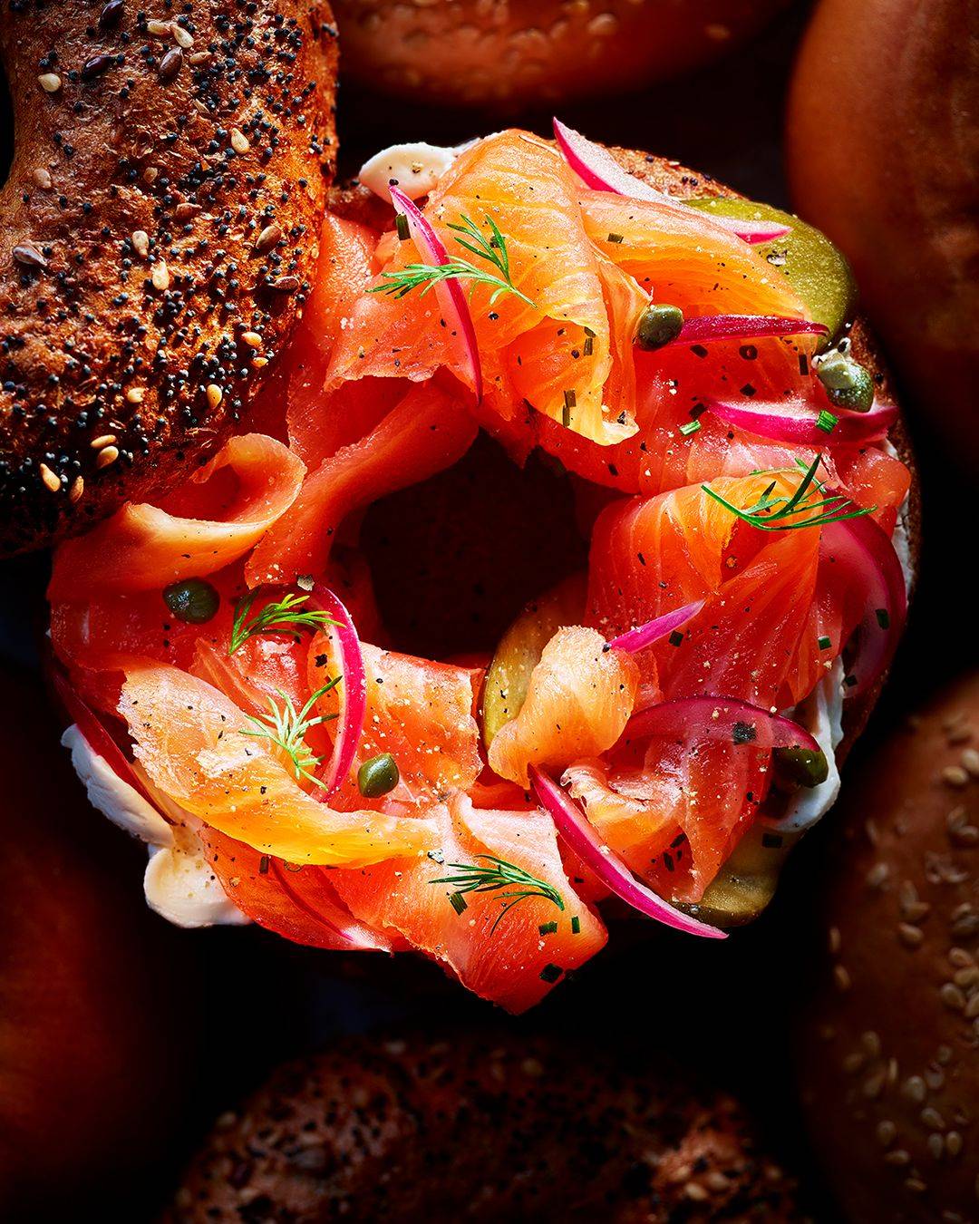 Food stylist adjusting a sandwich on a studio set during a food styling shoot