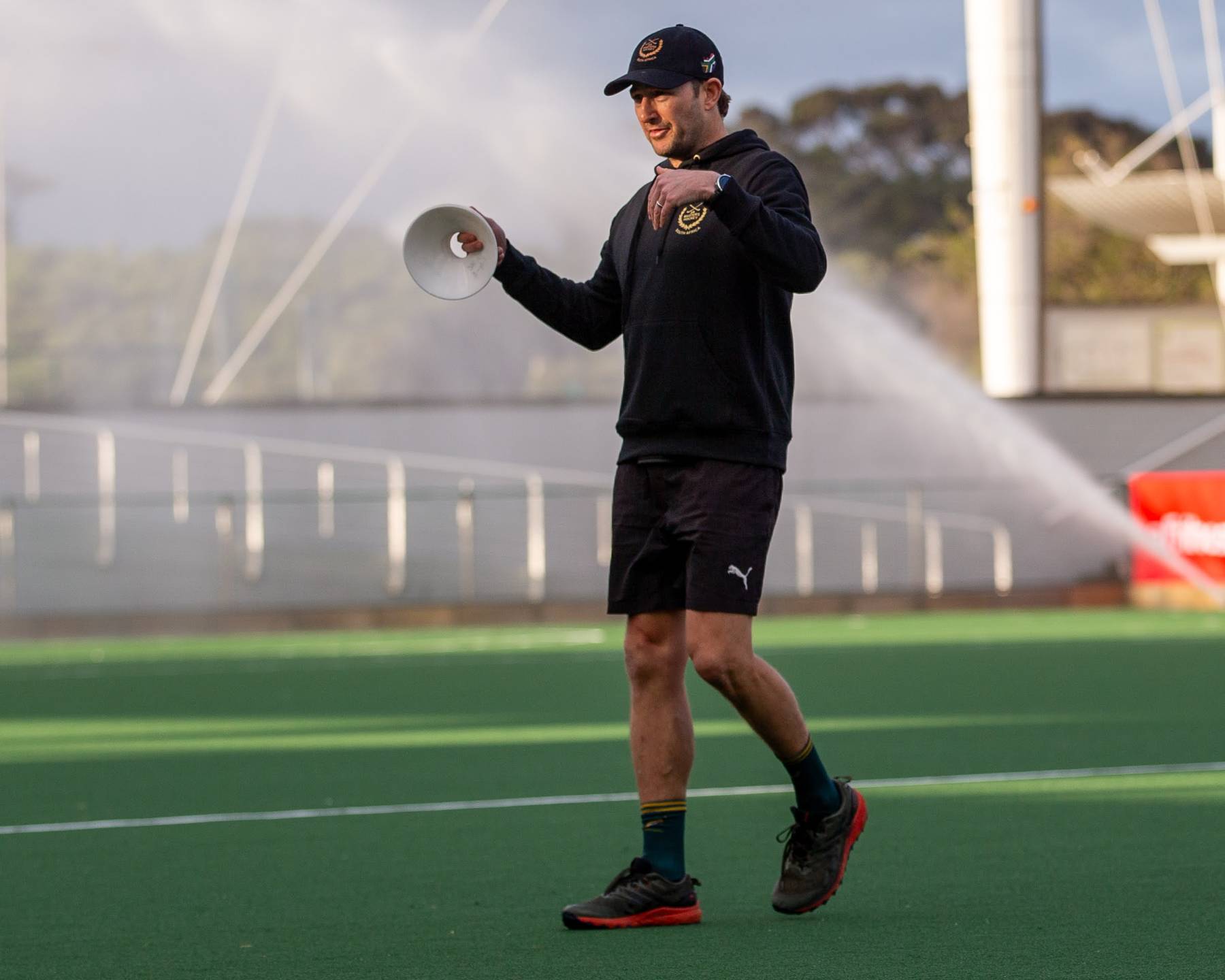 Biokineticist Rogan Heyns coaching a drill on a hockey pitch