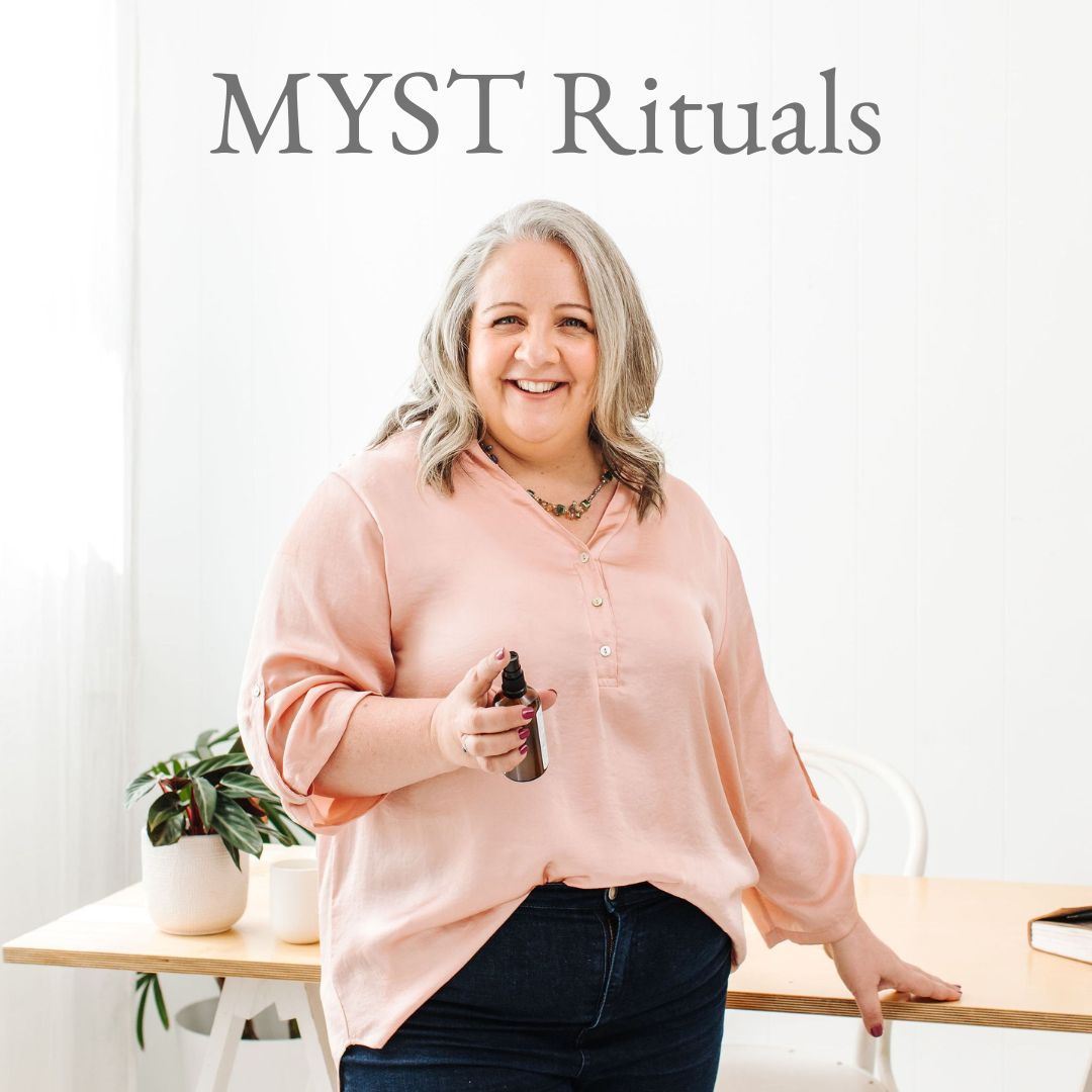 Nicki Kuurman sitting a desk shuffling oracle cards facilitating The Quick Fix - LIVE