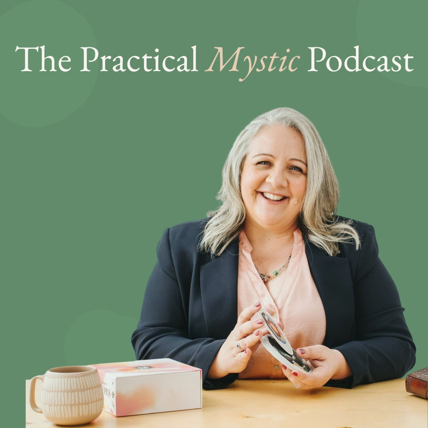Nicki Kuurman sitting at her desk with oracle cards promoting the Practical Mystic Podcast