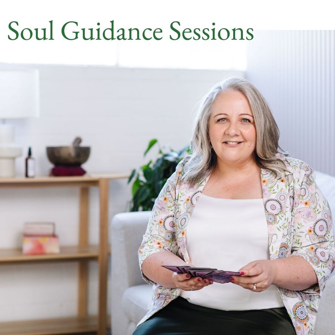 Nicki Kuurman sitting on sofa shuffling oracle cards for a Soul Guidance Session