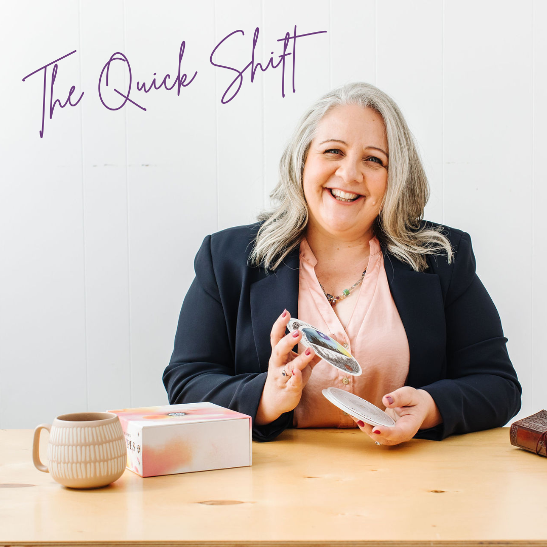 Nicki Kuurman sitting a desk shuffling oracle cards facilitating The Quick Fix - LIVE