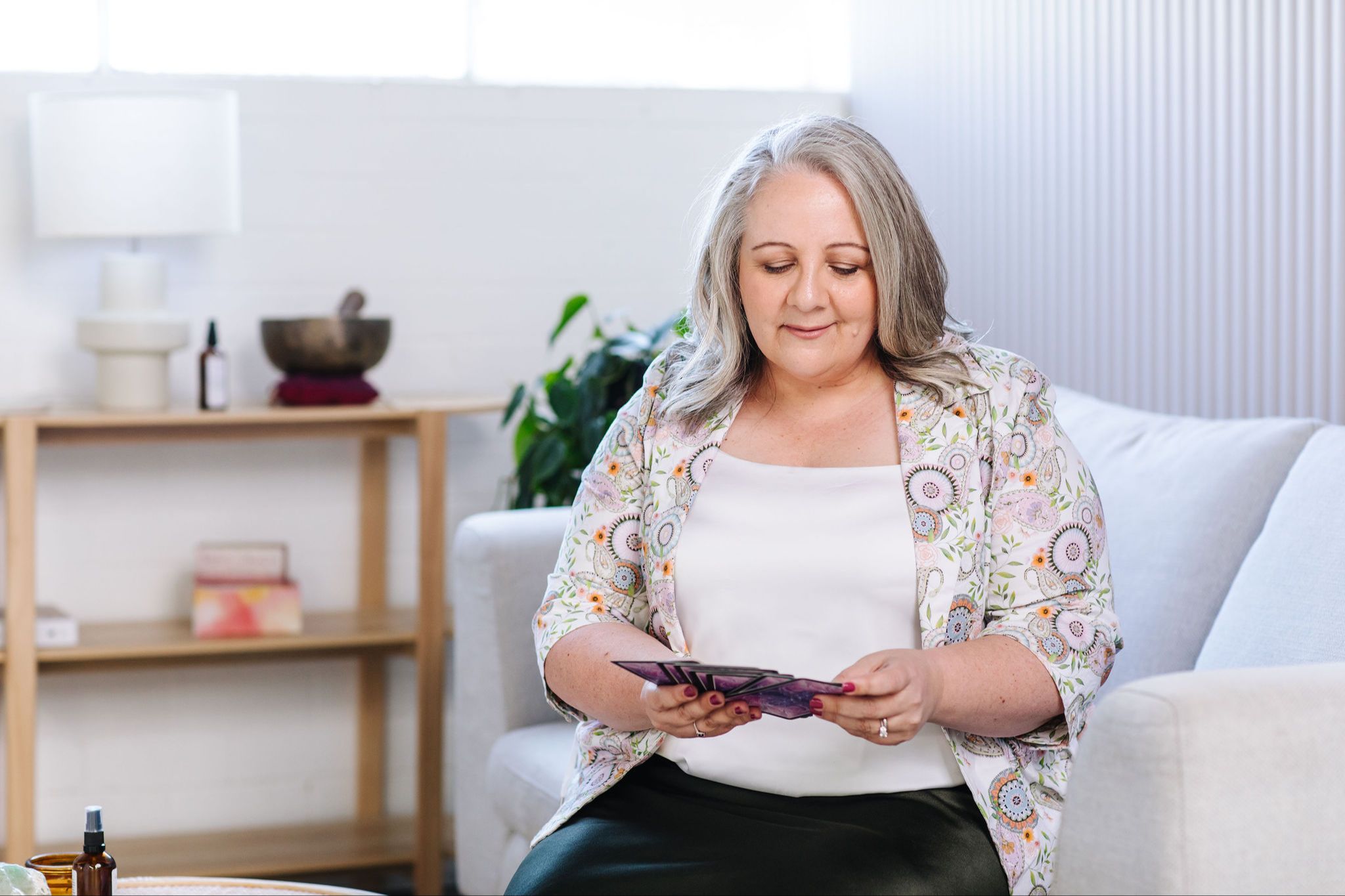 Nicki Kuurman looking down at oracle cards for a 1:1 session