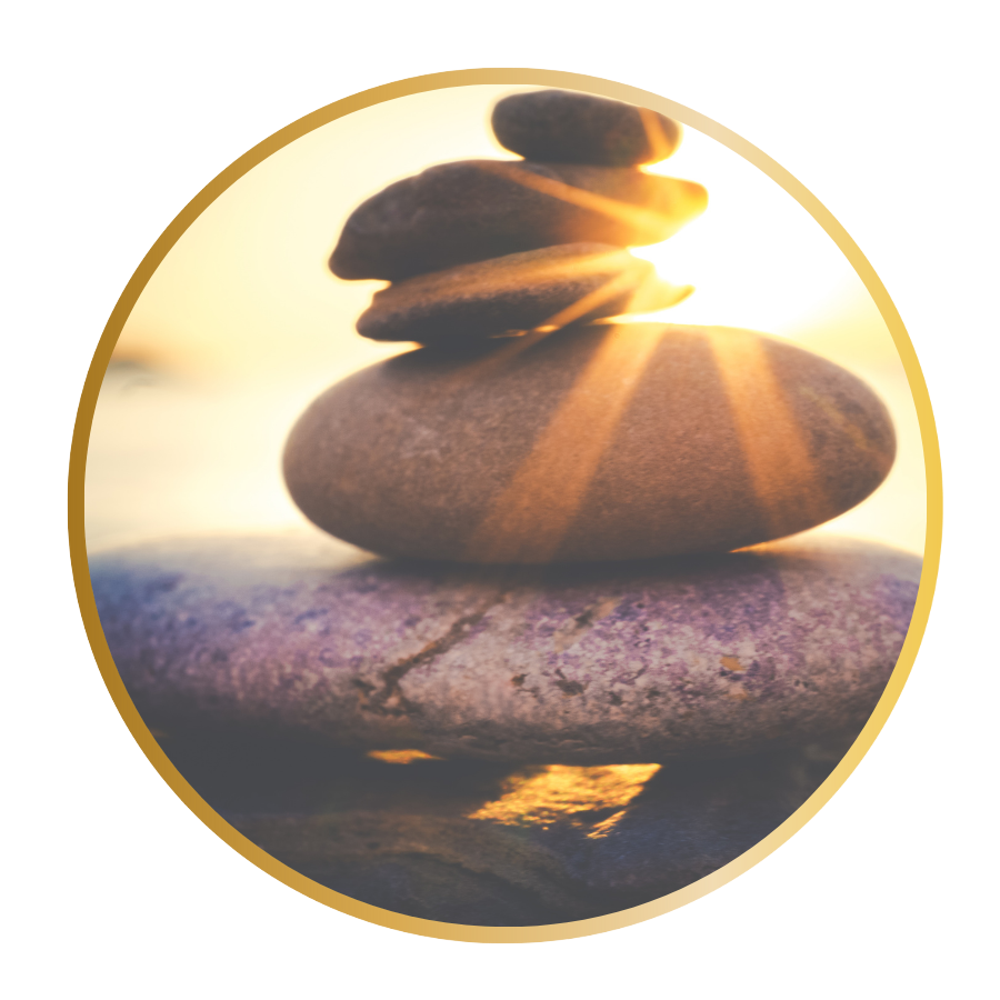 5 stones are stacked and balanced as light shines in the background