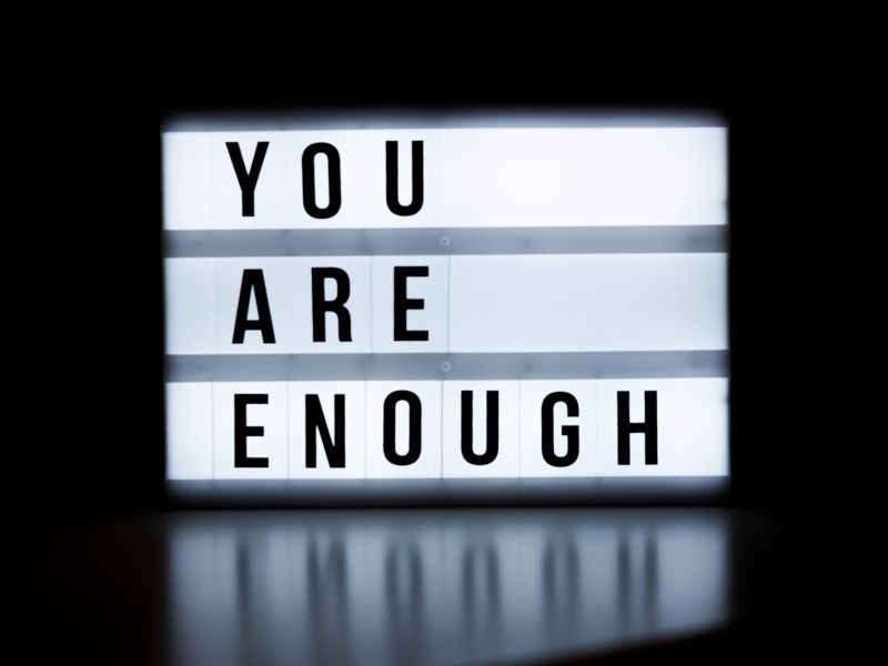 A glowing lightbox sign displaying the words “You Are Enough,” representing self-worth, self-acceptance, and personal empowerment.