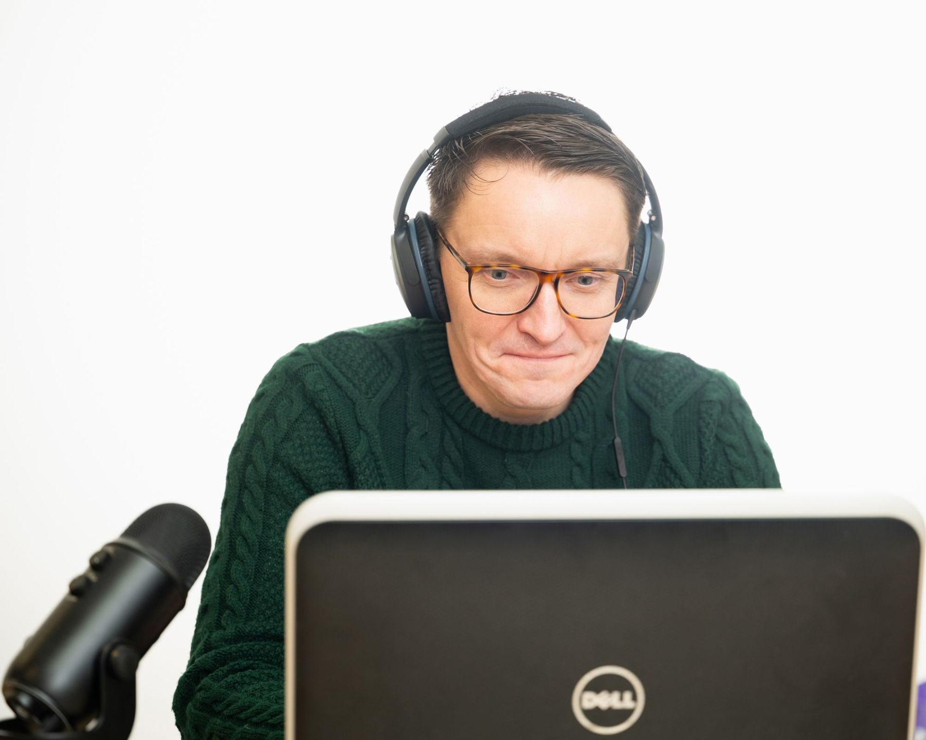 Gareth Collins of Retrained Minds Hypnotherapy working at a laptop with microphone and headphones, during an online hypnotherapy session.
