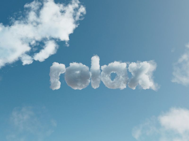 The word relax formed from soft white clouds in a clear blue sky symbolising calm, peace of mind, and the lightness achieved through hypnotherapy.