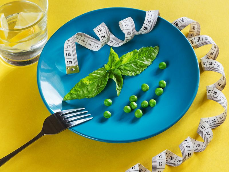 Blue plate with green vegetables and a measuring tape, symbolising mindful eating, balance, and the journey towards healthy weight loss — Retrained Minds Hypnotherapy.
