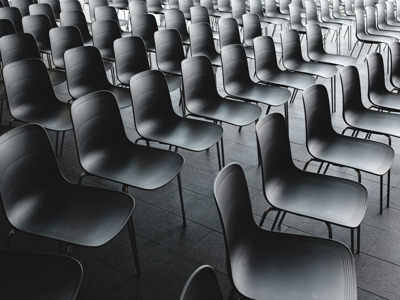 Rows of empty chairs in a seminar room symbolising public speaking anxiety and performance preparation, used for Retrained Minds Hypnotherapy page.
