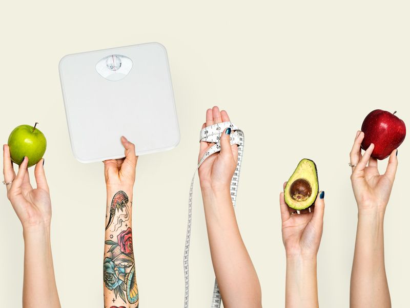 Hands holding healthy foods, a weighing scale, and a tape measure, symbolising balance, motivation, and a positive approach to healthy weight loss - Retrained Minds Hypnotherapy.