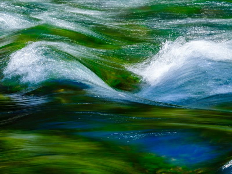 Soothing green and blue flowing river water symbolising calm, ease, and relaxation for anxiety relief hypnotherapy.