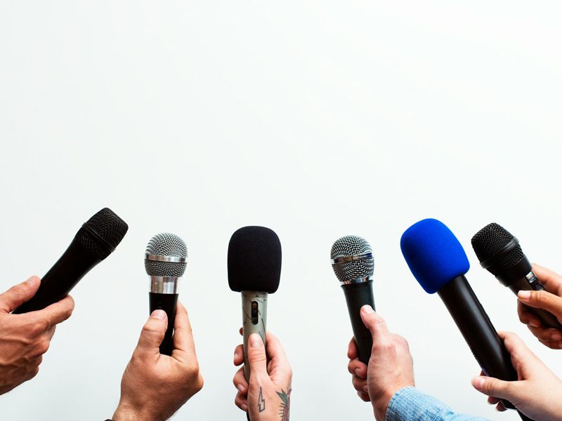 Hands holding microphones facing forward, symbolising confidence, communication, and public speaking hypnotherapy.