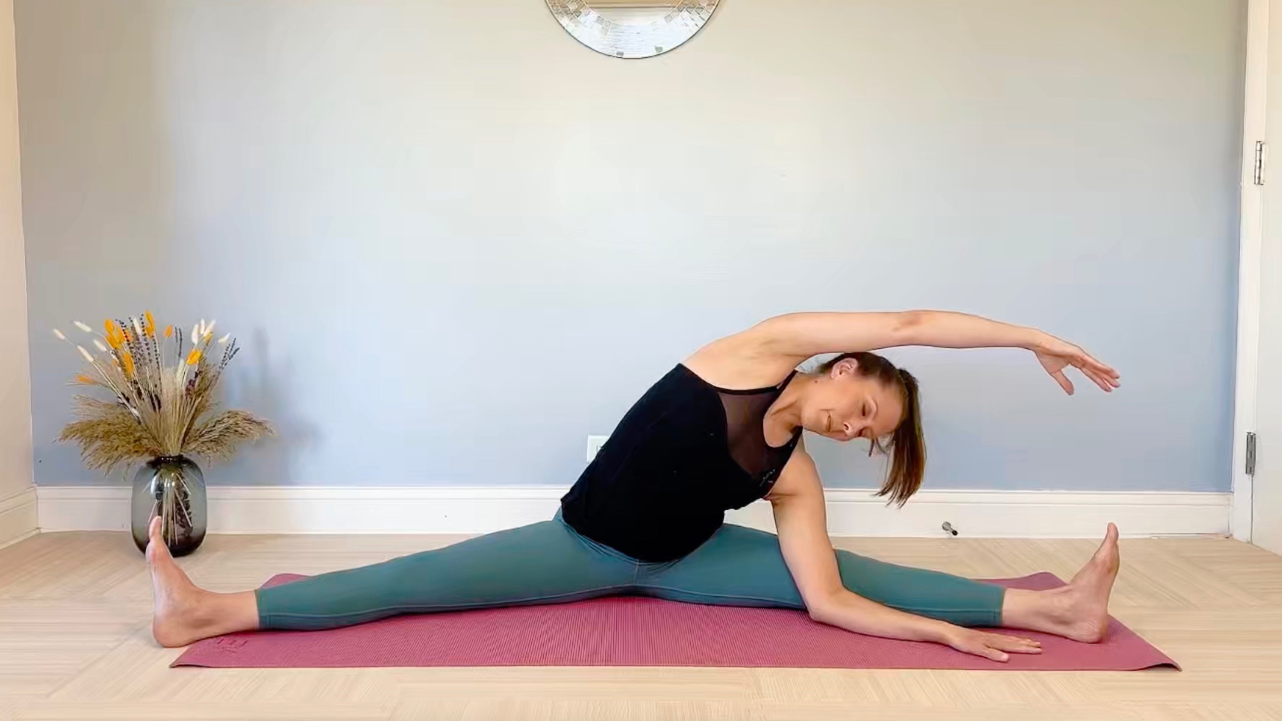 Woman on a yoga mat doing a side bend stretch—part of the Stretching Course for Be Well My Body On Demand.