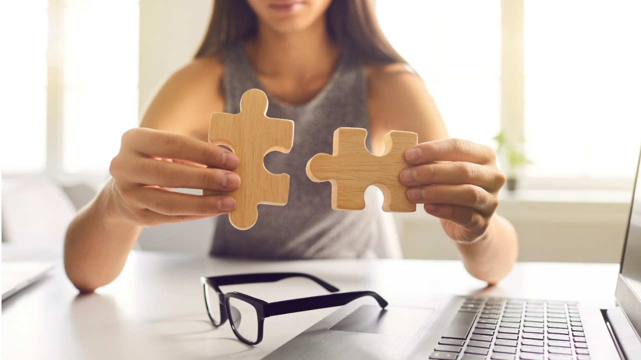 a lady holding 2 puzzle pieces to train her brain