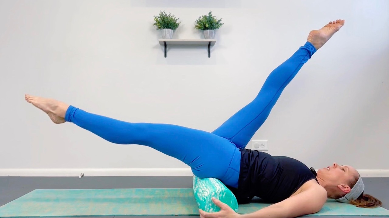 Woman on yoga mat with Pilates ring in back extension—part of the Pilates Mat Course in the Complete Wellness Bundle