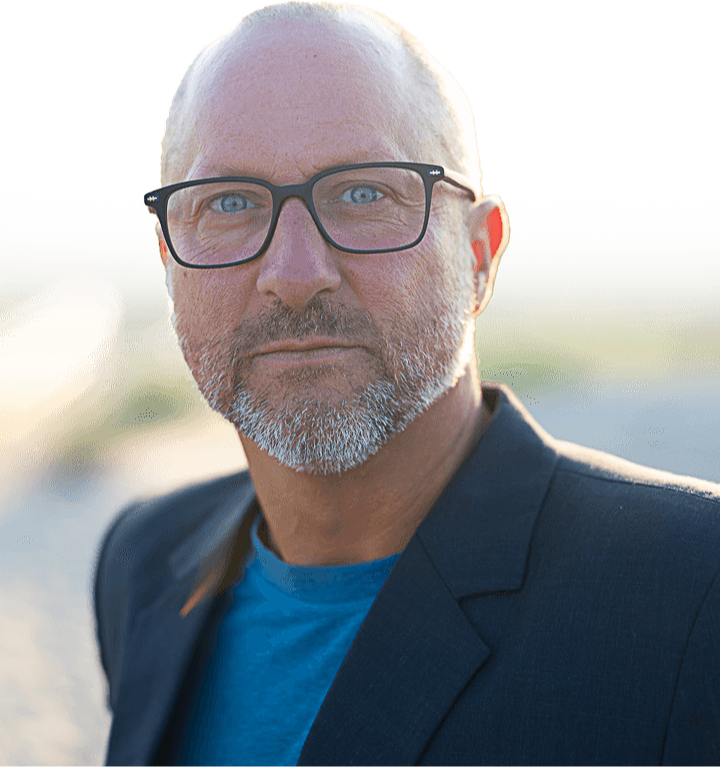 Image of a man with glasses on his head and beard
