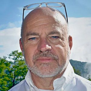Image of a man with glasses on his head and beard