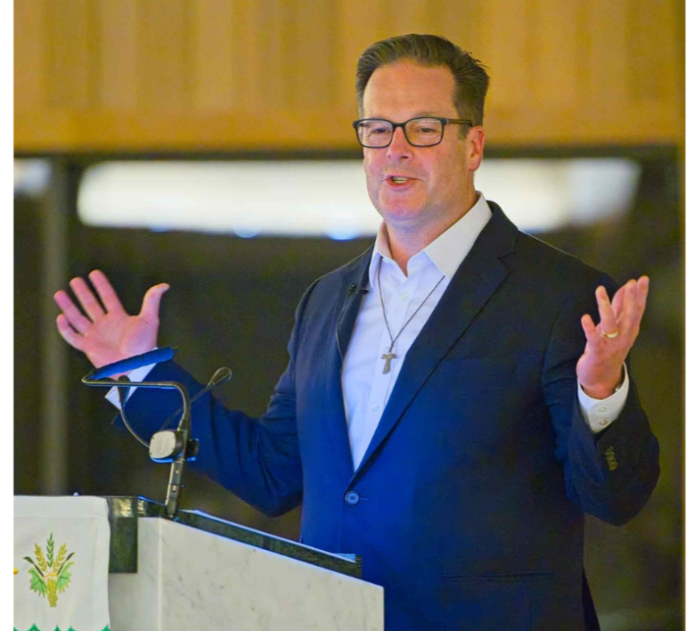 Kevin Zerrenner, CEO of CLARITAS Ministries and Power of Mass course instructor, wearing a suit and taking a selfie outside of a Catholic church