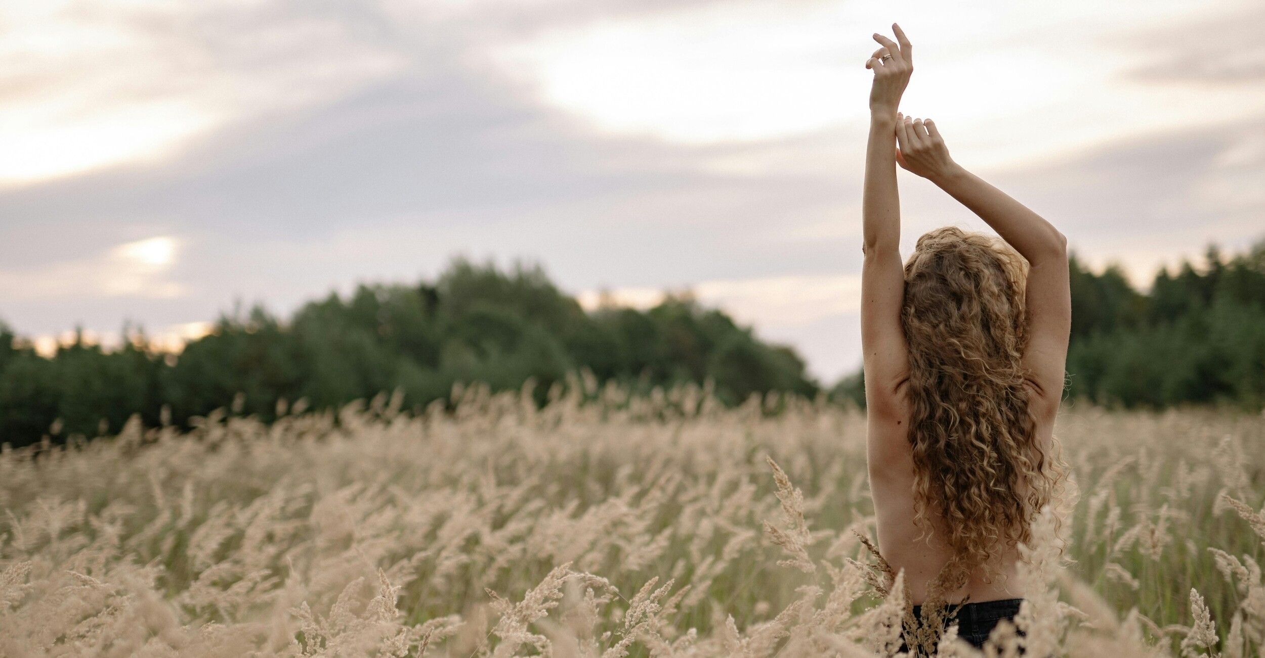 woman standing naked in field