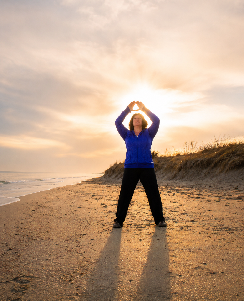 Maria Furlano practicing Medical Qìgōng Spleen exercise, on a peaceful beach at sunrise, reflecting the grounded, intentional approach of Frequency Tuning™.