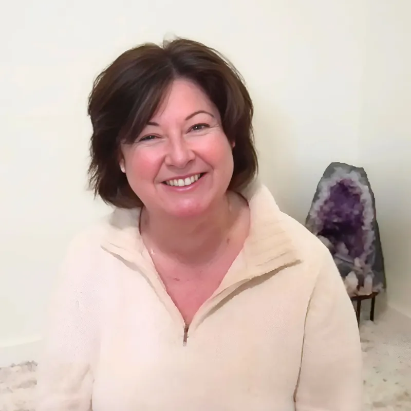 Maria Furlano meditating in front of many tree roots (black and white image)