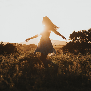 Silhouette of a woman in nature, twirling 