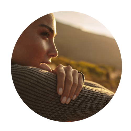 close up image of a women's face looking into the distance. She is in nature. 