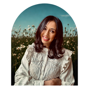 Image of euroasian woman, hands folded over torso. Nature background with flowers and soft lighting.