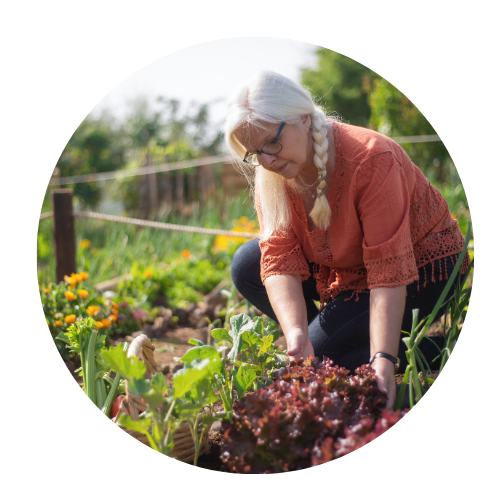 older woman, her hair in a plait. She is gardening.
